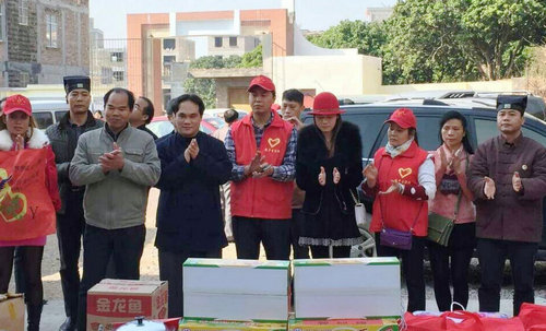 广西道教协会副会长陈应伟和志愿者一起为贫困户发放物品